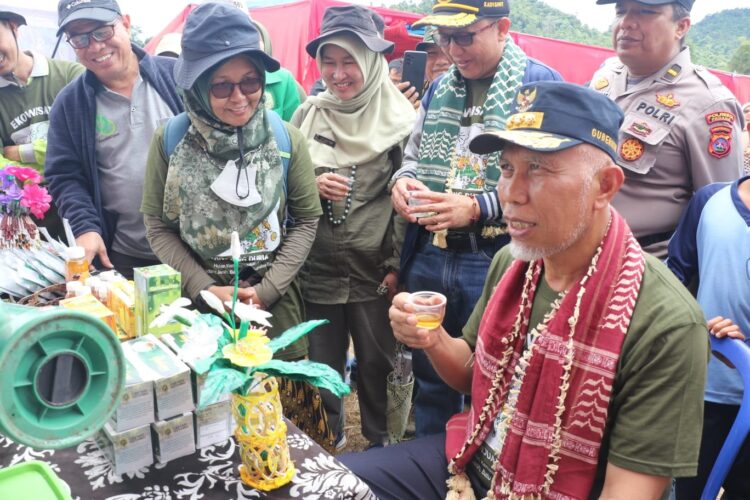 NIKMATI GAHARU GAMBIR—Gubernur Mahyeldi didampingi Kadis Kehutanan, Yozarwardi, menikmati teh gaharu gambir, saat meresmikan Festival Perhutanan Sosial Sumbar di Padang Janiah, Kampung Batu Busuak, Lambuang Bukik, Kota Padang, Sabtu (15/10).