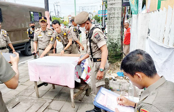BERJUALAN DI ATAS TROTOAR— Petugas Satpol PP kembali menertibkan PKL yang berjualan memakai fasum di sepanjang jalan Proklamasi, Selasa (4/10). Pedagang di kawasan ini sudah sering ditegur, namun masih tetap membandel dan memakai trotoar untuk meletakkan lapak dan gerobak.
