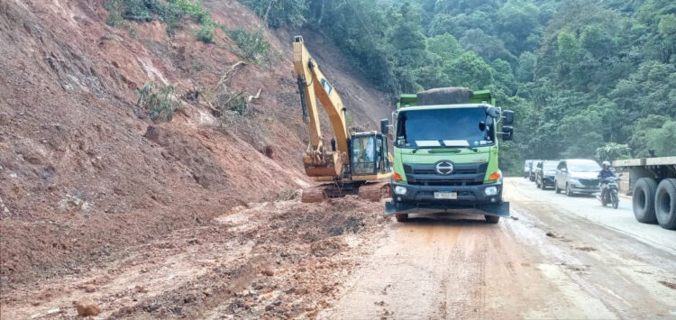 BERSIHKAN—Alat berat ekskavator bekerja membersihkan material longsor di jalur Sitinjau Lauik, Kecamatan Lubuk Kilangan Kota Padang yang mengalami longsor berulang kali, kini mulai berangsur normal kembali.
