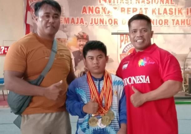 DIAPIT— Lifter Ari Saputra diapit oleh kedua pelatih.