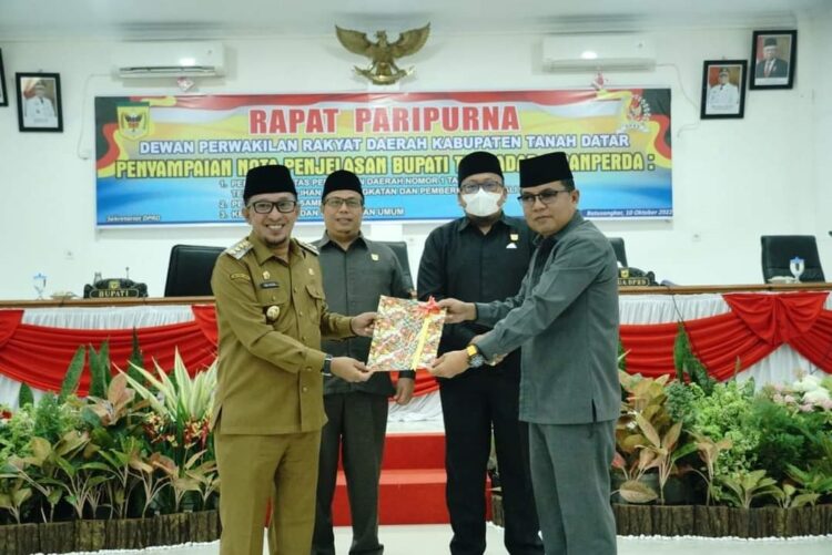 SERAHKAN NOTA— Wakil Ketua DPRD Tanah Datar Anton Yondra menerima naskah 3 Ranperda yang diserahkan Bupati Eka Putra, saat sidang paripurna, Senin (10/10).