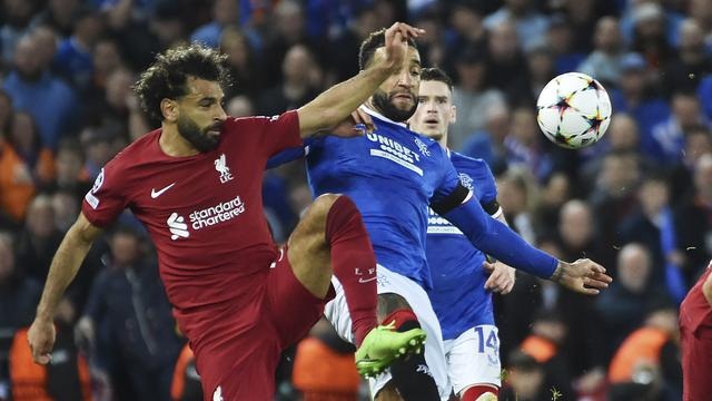 BEREBUT BOLA— Muhamed Salah berebut bola dengan bek Rangers Connor Goldson dalam matchday 3 fase grup UCL 2022/2023 di stadion Anfield, Rabu (5/10) dinihari WIB.