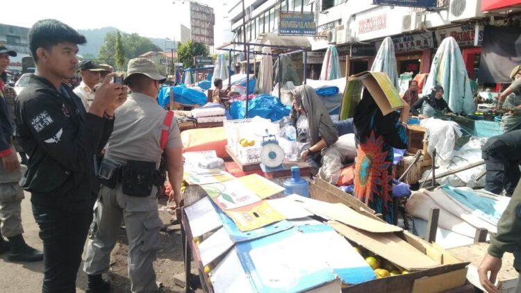 PENERTIBAN PKL— Satu pleton pasukan Satpol PP bersama Dinas Perdagangan melakukan penertiban PKL di Jalan Pasar Raya Barat, Kamis (19/1). Meski sudah sering ditegur dan diberi peringatan, masih banyak PKL yang bandel dan nekat memakai badan jalan untuk meletakkan dagangan, payung dan lainnya sehingga menyebabkan kemacetaan serta kesemrawutan di kawasan Pasar Raya Barat.