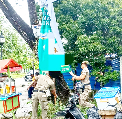 REKLAME ILEGAL— Petugas Satuan Polisi Pamong Praja Kota Padang membongkar dan melepas sejumlah spanduk, banner, maupun baliho liar yang melanggar aturan di Kecamatan Padang Utara, Selasa (24/1). Petugas juga mencopot reklame yang ditancap di batang pohon pelindung.