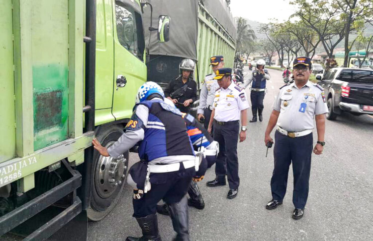 Parkir Liar di Ruas Indarung-Lubeg Rawan Kecelakaan, 15 Truk Digembosi, Sopir Protes 1 BAN TRUK DIGEMBOSI— Kepala Dishub Kota Padang Yudi Indra Syani, petugas Bidang Ops dan Keselamatan bersama aparat Polsek Lubuk Kilangan melakukan penertiban terhadap truk-truk yang masih bandel dengan memarkirkan kendaraan di ruas jalan Indarung-Lubukbegalung, Kamis (26/1) pagi.