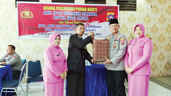 BERI CINDERA MATA— Kapolsek Koto Tangah AKP Afrino bersama istri, berikan cindera mata kepada AKP Muzhakir Sandra