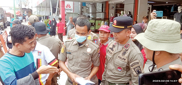 PKL MASIH MENOLAK— Penertiban yang dilakukan Satpol PP Padang di kawasan Pasar Raya Padang, Senin (6/2) siang masih “memanas”. PKL terlibat adu argumen dan meminta untuk diperbolehkan berjualan lebih cepat.