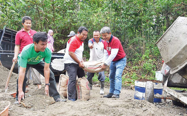 BETONISASI JALAN— Jajaran staf CSR PT Semen Padang yang dipimpin Kepala Unit, Rinold Thamrin, mengikuti aksi goro bersama warga Bukit Gaduik, Kelurahan Limau Manis Selatan, Kecamatan Pauh, untuk membuka akses jalan Gaduik Ketek sepanjang 1 km.