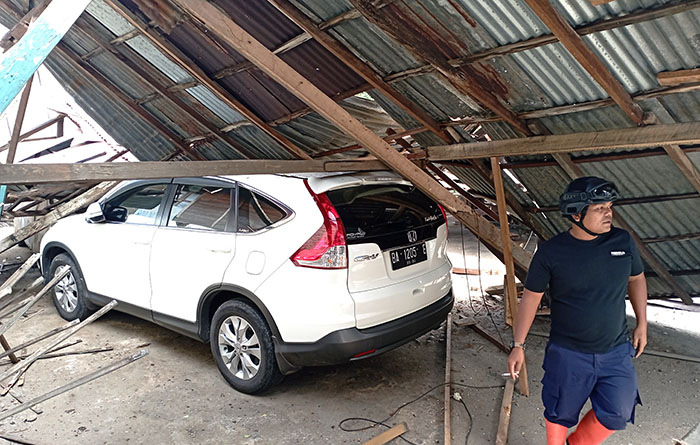 BENGKEL ROBOH— Kondisi salah satu mobil yang tertimpa bangunan bengkel yang roboh.