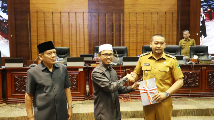 SERAHKAN--Wakil Ketua DPRD Sumbar, Irsyad Syafar menyerahkan berkas nota penjelasan terhadap Rancangan Peraturan Daerah (Ranperda) tentang Pelestarian dan Pemajuan Kebudayaan Daerah kepada Wakil Gubernur Sumbar, Audy Joinaldy, dalam rapat paripurna , Senin (6/2,) di Ruang Sidang Utama DPRD Sumbar.