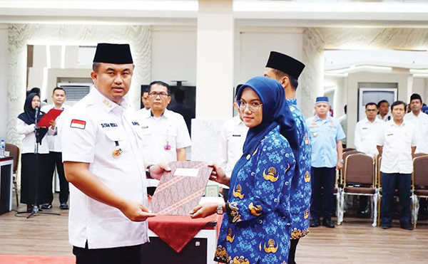 49 PNS Pemkab Dharmasraya Dilantik, Sutan Riska Tekankan PNS Profesional, Disiplin dan Layani Masyarakat dengan Hati 1 SERAHKAN SK— Bupati Dharmasraya Sutan Riska Tuanku Kerajaan menyerahkan SK 100 persen PNS kepada salah perwakilan PNS yang dilantik.