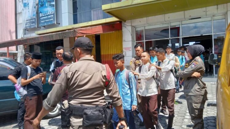 MAIN GAMES— Puluhan pelajar dari berbagai sekolah di Kota Padang terjaring razia Satuan Polisi Pamong Praja (Satpol PP) Kota Padang, Jumat (12/5) siang, di kawasan Nanggalo. Mereka terjaring razia saat bermain games station di tengah proses belajar mengajar (PBM) berlangsung.