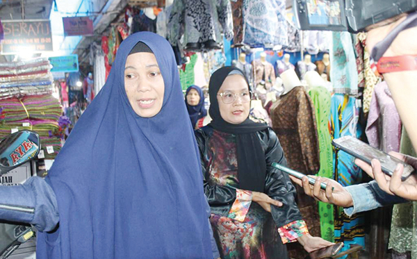 KELUHAN PEDAGANG— Sejumlah pedagang baju, kain yang ada di Fase III Pasar Raya Padang curhat kepada wartawan, Senin (29/5), perihal omzet mereka yang tiap hari makin menurun, akibat kondisi PKL yang tidak tertata dengan baik, parkir semrawut dan retribusi iuran.