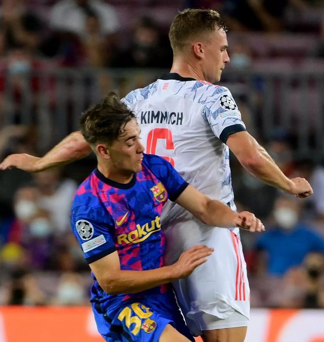 DUEL— Gelandang 17 tahun dari FC Barcelona, Gavi, berduel dengan gelandang Bayern Muenchen Joshua Kimmich di Camp Nou.