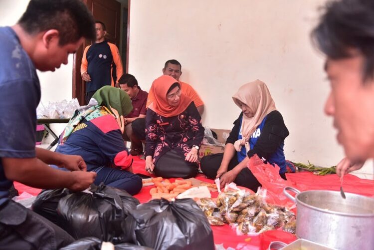 MEMASAK—Para ini ibu asyik memasak di dapur umum posko penanganan darurat bencana tanah longsor di Kota Sawahlunto untuk 1.050 porsi nasi bungkus setiap harinya.