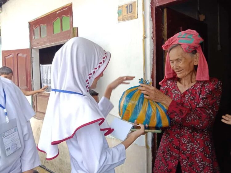 SERAHKAN SEMBAKO—Siswa kelas VI A SDN 7 Padang Panjang Barat (PPB) saat menyerahkan sembako pada warga lansia.