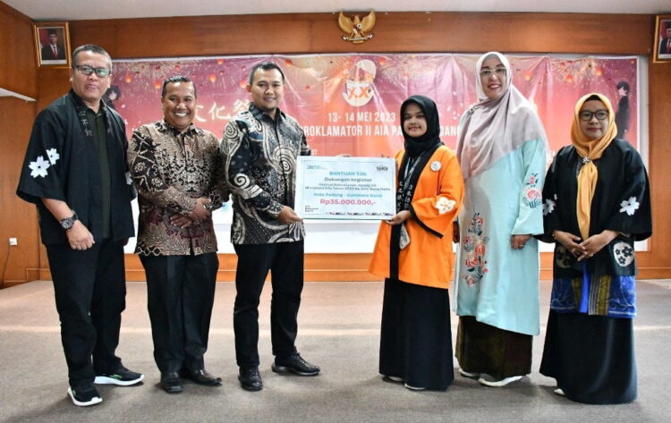 FESTIVAL BUNKASAI— Ka. Sie PUMK Unit CSR PT Semen Padang, Satrio Rian Bhakti, menyerahkan uang tunai kepada Ketua Panitia Festival Bungkasai ke-20, Jelita Maharani, usai pembukaan Festival Bunkasai dengan tema ‘Hajimaru’, di Kampus Proklamator II Aia Pacah Sabtu (13/5).