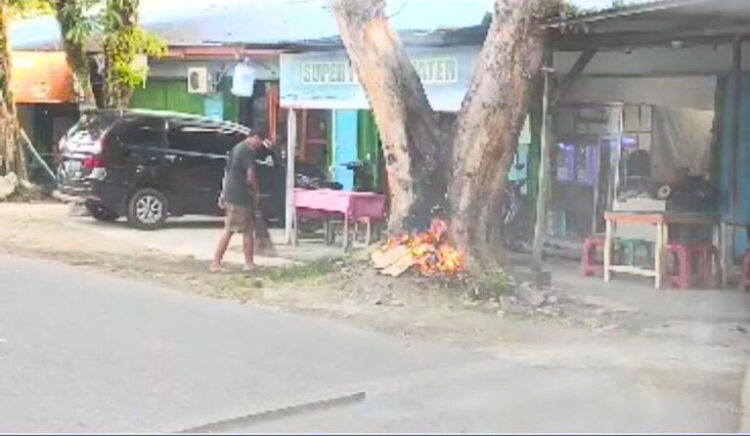 MEMBAKAR DI POHON— Sebuah video menunjukkan aktvitas pelaku usaha galon yang membakar sampah di pohon pelindung. Akibatnya, pohon menjadi rusak karena pembakaran terus menerus.
