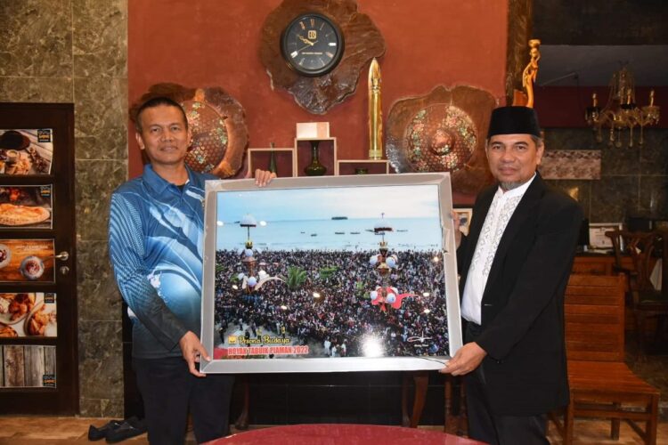 FOTO TABUIK— Wako Pariaman H Genius Umar saat menyerahkan foto tabuik pada pengurus PKDP.