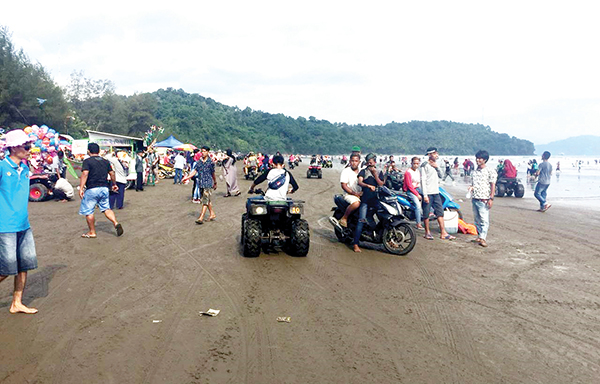 DIPADATI PENGUNJUNG— Suasana Pantai Air Manis yang dipadati oleh pengunjung disaat musim liburan sekolah tiba.
