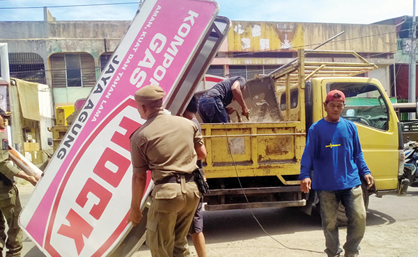 TAK BAYAR PAJAK— Petugas Bapenda Kota Padang bersama Tim SK-4 dan Satpol-PP melakukan penertiban terhadap sejumlah papan iklan/reklame kepada wajib pajak yang belum membayar pajak iklan, Kamis (8/6).
