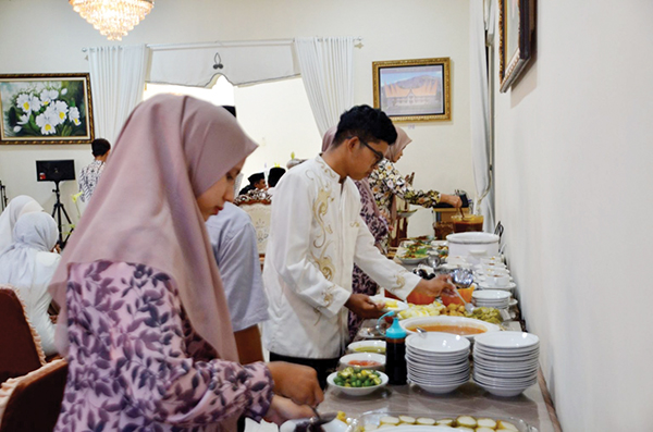 NIKMATI MAKANAN— Sejumlah tamu dan warga menikmati hidangan khas lebaran saat open house yang digelar Bupati Agam Andri Warman, di rumah dinas bupati, Kamis (29/6).