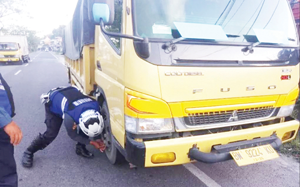 BAN DIGEMBOSI— Petugas gabungan dari Dinas Perhubungan dan Polsek Lubuk Kilangan, melakukan penggembosan terhadap truk yang parkir sembarangan dan membahayakan pengendara lain, di sepanjang jalan kawasan Indarung, Kecamatan Lubuk Kilangan.