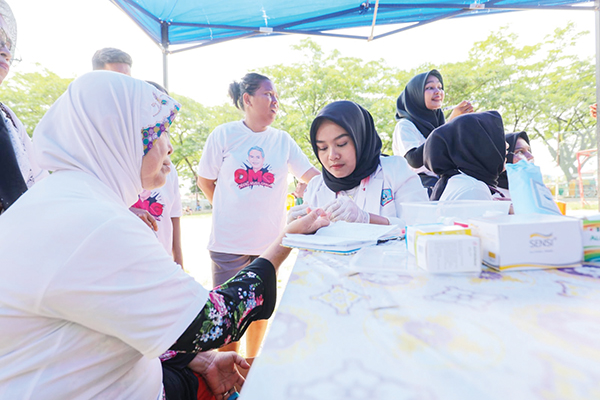 CEK KESEHATAN GRATIS— Sukarelawan OMG melakukan pemeriksaan kesehatan gratis kepada masyarakat di Kelurahan Batang Arau, Kecamatan Padang Selatan, Kota Padang, sekaligus mendeklarasikan dukungan kepada Ganjar Pranowo sebagai presiden Indonesia pada 2024-2029, Minggu, (4/6).