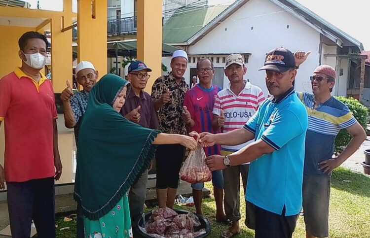 SERAHKAN DAGING KURBAN— Ketua panitia kurban Masjid At- Taubah, Imam Gunawan didampingi AKBP Andi Sentosa, menyerahkan daging kurban pada warga, Kamis (29/6).