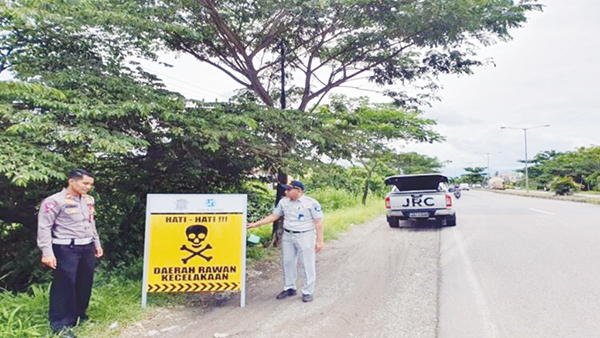 PEMASANGAN PLANG— Kanit Laka Lantas Polresta Padang Iptu Arisman, saat memasang plang imbauan bertuliskan “Hati-hati, Daerah Rawan Kecelakaan” dan “Jangan Ngebut, Kecelakaan Diawali Dengan Pelanggaran” dipasang di beberapa sudut jalan di kawasan Bypass, Kamis (15/6).