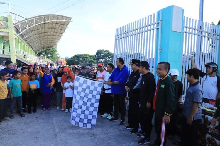 ANGKAT BENDERA— Wali Kota Solok Zul Elfian mengangkat bendera star saat melepaspeserta jalan santai.