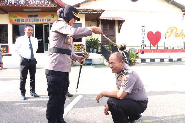 Kasi Humas Polresta Bukittinggi Naik Pangkat menjadi Komisaris Polisi 1 PROSESI KENAIKAN PANGKAT— Kapolresta Bukittinggi Kombes Pol Yessi Kurniati S.I.K., M.M., melakukan prosesi kenaikan pangkat kepada AKP Sitinjak, SH. Bertepatan dengan HUT Bhayangkara ke-77, perwira polisi ini mendapat kenaikan pangkat menjadi Komisaris Polisi (Kompol)