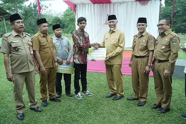 SERAHKAN BANTUAN— Gubernur Sumbar, Mahyeldi Ansharullah menyerahkan bantuan dan kayu hasil tangkapan untuk pembangunan dua mushalla di Nagari Padang Laweh Selatan, Kabupaten Sijunjung, Selasa (18/7).