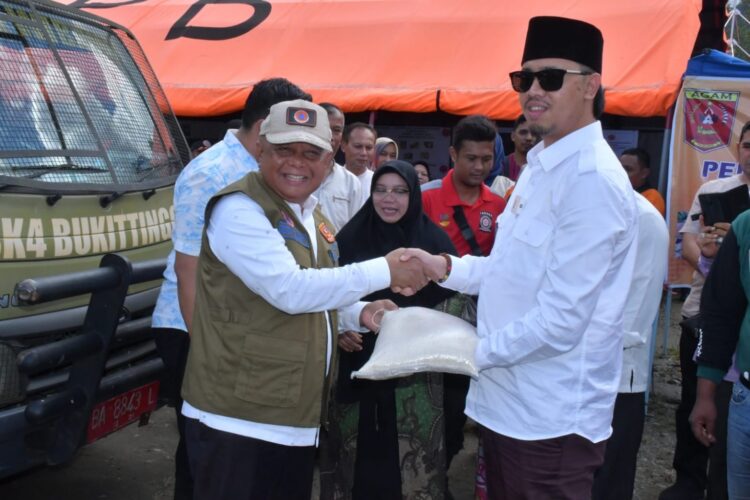 SALURKAN BANTUAN— Wali Kota Bukittinggi Erman Safar salurkan bantuan untuk korban bencana alam di Kecamatan Tanjung Raya yang diserahkan secara simbolis kepada Sekda Agam Drs Edi Busti MSi di Posko Penanggulangan Bencana, di Muko-muko, Kecamatan Tanjung Raya, Jumat (21/7).