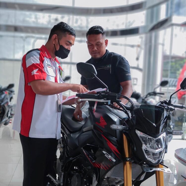 LAYANI KONSUMEN— Sales marketing PT Menara Agung melayani konsumen yang melakukan pembelian Honda CB150R.