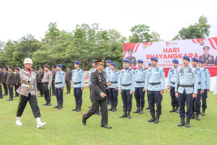 PERIKSA PASUKAN— Kapolres Sawahlunto AKBP  Purwanto Hari Subekti saat periksa barisan peserta upacara HUT Bhayangkara 77, Sabtu (1/7), di lapangan Camping Ground Kandih, Kota Sawahlunto.
