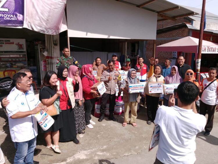 BANTUAN— Pertamina dan Hiswana Migas Sumatera Barat berbagi kasih membantu warga yang terdampak banjir di beberapa posko bantuan.