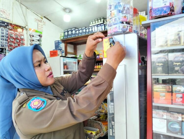 PASANG STIKER PERINGATAN— Anggota Satpol PP tempelkan surat peringatan dilarang merokok.