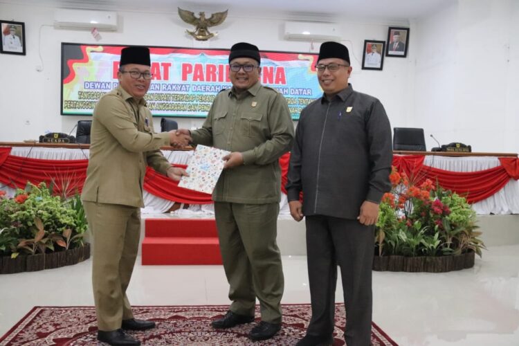 SERAHKAN NOTA JAWABAN—Sekda Iqbal menyerahkan nota jawaban atas pandangan umum fraksi fraksi DPRD Tanahdatar yang diterima ketua H.Roni Mulyadi.