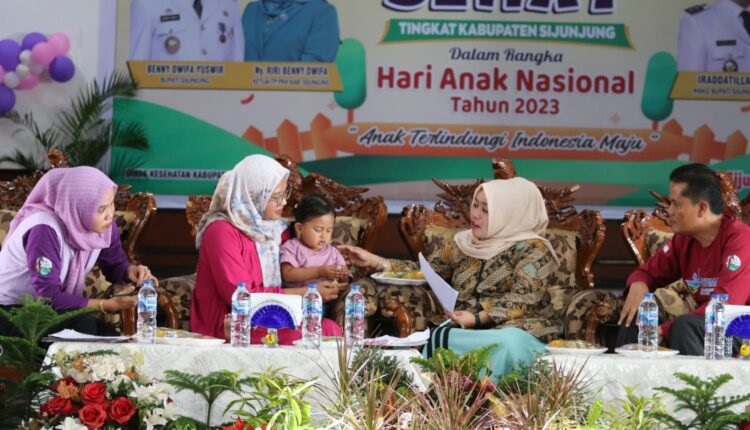 Ketua TP PKK Kabupaten Sijunjung Ny. Riri Benny Dwifa sedang bercengkrama dengan seorang balita