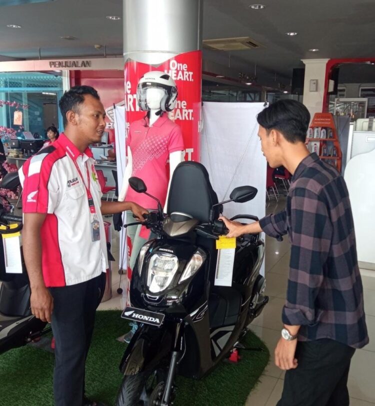 LAYANI KONSUMEN— Sales marketing PT Menara Agung melayani konsumen yang melakukan pembelian Honda Genio.