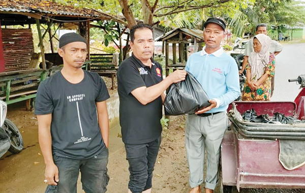TURUT BERDUKA— Wakil Sekretaris DPD Gerindra Sumbar Zulkifli memimpin pembagian nasi bungkus dari Anggota DPR RI Andre Rosiade, kepada warga korban banjir di sejumlah kelurahan di Kota Padang, Jumat (14/7).