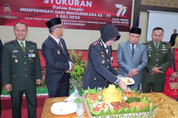 POTONG TUMPENG— Kapolres Payakumbuh AKBP Wahyuni Sri Lestari memotong tumpeng, disaksikan Pj Wako Rida Ananda, Ketua DPRD, Forkopimda saat syukuran HUT Bhayangkara ke-77.