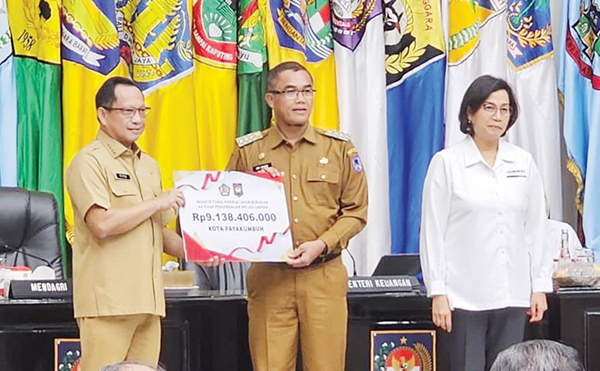 MENDAGRI Tito Karnavian menyerahkan penghargaan kepada Pj. Wali Kota Payakumbuh Rida Ananda disaksikan Menteri Keuangan Sri Mulyani.