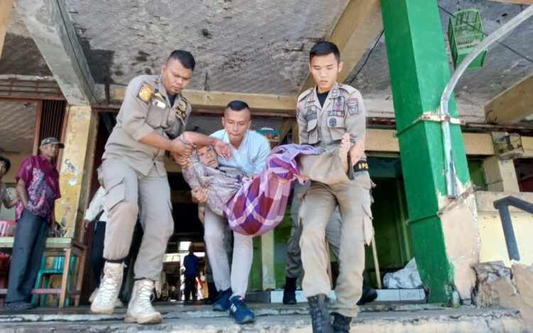 Kakek Tua Ditemukan Terbaring Lemas di Padang Theater 1 TERLANTAR— Petugas Satpol PP mengangkut kakek tua yang ditemukan terlantar di salah satu blok lantai dua Padang Theater, Pasar Raya Padang, Jumat (11/8).