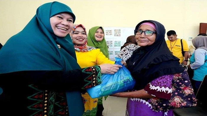 SERAHKAN BANTUAN— Ketua LKKS Sumbar Harneli serahkan bantuan sembako pada keluarga kurang mampu di kantir Dinsos PPA Sijunjung.