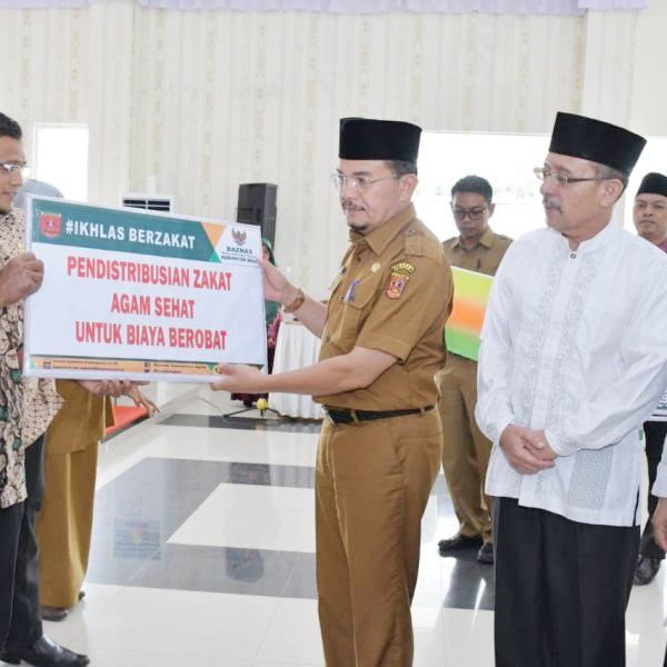 PENYALURAN BANTUAN— Asisten II Setdakab Agam, Jetson menyalurkan zakat dari Baznas Agam senilai Rp272,4 juta kepada 210 mustahik, di Balairung Rumah Dinas Bupati Agam, Selasa (29/8).