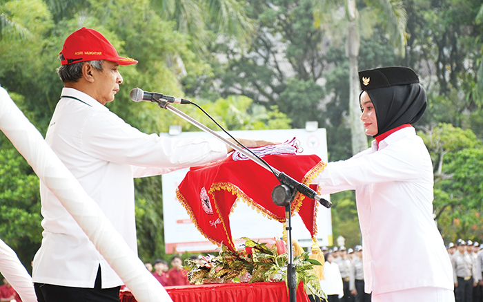 SERAHKAN BENDERA— Dirut PT Semen Padang Asri Mukhtar menyerahkan bendera merah putih kepada anggota paskibraka yang merupakan karyawati Semen Padang, saat menjadi inspektur upacara bendera peringatan HUT Kemerdekaan RI ke-78, Kamis (17/8) di Plaza Kantor Pusat PT Semen Padang.