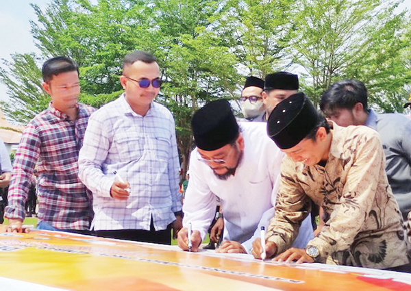 TANDATANGAN— Senator DPD RI Leonardy Harmainy ikut menandatangani bentangan spanduk Deklarasi Pemilu Damai 2024 yang disiapkan Sudbit I Ditintelkam Polda Sumbar, Kamis (24/8).