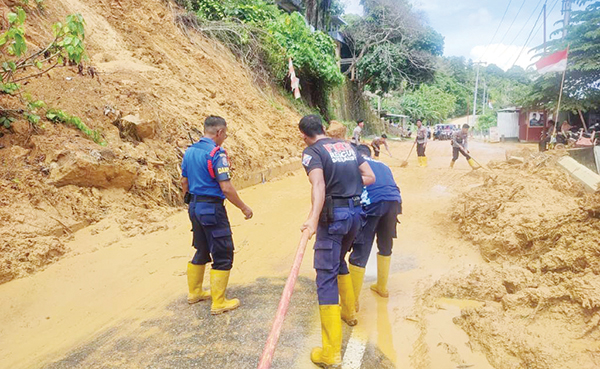 PEMBERSIHAN MATERIAL LONGSOR— Petugas gabungan dari SAR Dit Samapta Polda Sumbar, dan personel Damkar Kota Padang bertugas menyiram air untuk membersihkan sisa-sisa tanah Material longsor yang masih tertinggal, Senin (28/8).